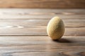 A textured ovular object rests on a rustic wooden surface. Generative AI Royalty Free Stock Photo