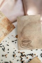 Textured paper cards with coffee drops and a picture of a coffee cup on a pink silk fabric background Royalty Free Stock Photo