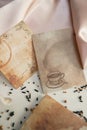 Textured paper cards with coffee drops and a picture of a coffee cup on a pink silk fabric background Royalty Free Stock Photo