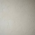 A textured plaster wall with an uneven, abstract pattern. It features a light beige color Royalty Free Stock Photo