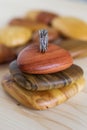 Textured silver ring on a wooden holder and soft wooden background. Handcraft precious item.