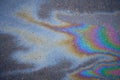 Textured stain of fuel or oil on wet asphalt on a rainy day