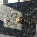 A textured stone slab features embedded mineral formations, including purple and Royalty Free Stock Photo
