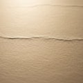 A textured surface of beige paper with a horizontal, slightly Royalty Free Stock Photo