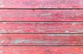 Textured surface of a horizontal wooden boards with a peeling and cracked layer of red paint. Old painted wood planks, aged Royalty Free Stock Photo