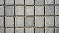 A textured surface of interlocking grey stone paving blocks with small plants sprouting between the joints. Generative AI Royalty Free Stock Photo