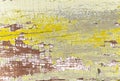 Textured surface of a old painted wooden board with a peeling and cracked layer of yellow and white paint closeup. Royalty Free Stock Photo