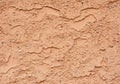 Textured surface resembling an adobe or stucco wall, characterized by a rough, uneven finish with a Royalty Free Stock Photo