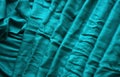 Textured turquoise cloth with folds. Woven background.