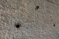 A textured wall displaying two small circular holes for drainage Royalty Free Stock Photo