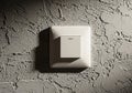 A textured wall with a light grey electrical switch plate mounted on Royalty Free Stock Photo
