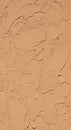 Textured wall surface with a rough, stucco-like finish in a warm Royalty Free Stock Photo