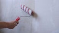 Applying wallpaper glue to the wall