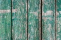 Textured weathered wooden surfase with vertical boards, cracked blue green