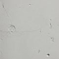 Textured white plaster wall featuring several small holes and cracks Royalty Free Stock Photo