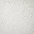 A textured white wall with irregular patterns and rough surfaces creates an abstract, Royalty Free Stock Photo
