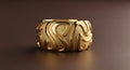 Textured wide golden ring with an abstract wavy pattern shown with soft studio lighting against a dark brown background Royalty Free Stock Photo