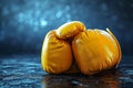 Textured yellow boxing gloves, set against a deep blue backdrop. Concept of focus and dedication in training, the Royalty Free Stock Photo