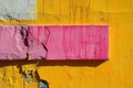 A textured yellow wall featuring a contrasting pink rectangular paint stroke, perfect for adding custom text or messages