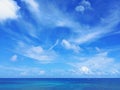 Tropical blue sky background with white cloud trails over caribbean sea. Soft white clouds in blue sky of the Caribbean. Textures Royalty Free Stock Photo