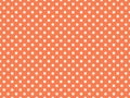 texturised white color polka dots over coral orange background