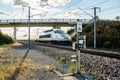 A TGV high speed train passing under a bridge in the french countryside with motion blur Royalty Free Stock Photo