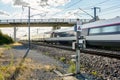 A TGV high speed train passing under a bridge in the french countryside with motion blur Royalty Free Stock Photo