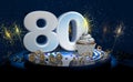 80th birthday or anniversary cupcake with big white number with yellow streamers on blue table with dark background full of sparks