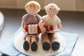 70th birthday cake decoration, deoicting 2 figures of old peolpe sitting together with a bottle of champagne