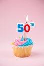 50th candle on a cupcake on a pink background Royalty Free Stock Photo