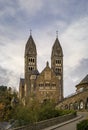 Stone neo romanesque catholic Church of Saints Come and Damien in Clervaux Luxembourg surrounded by a forest in the fall