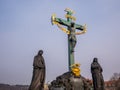 17th Century Crucifixion statue with Hebrew lettering blue sky in Charles Bridge Prague, Czech Republic .