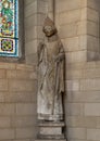 14th century French limestone statue of a standing bishop in the Cloisters in New York City.