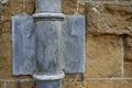 17th Century Lead downpipe detail on a yellow ironstone wall. England, UK.