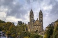 Stone neo romanesque catholic Church of Saints Come and Damien in Clervaux Luxembourg surrounded by a forest in the fall