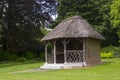 The 19th Century thatched summer house surrounded by beautiful flower beds and gravel paths in the walled garden at West Dean Royalty Free Stock Photo