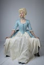 18th century woman with a blonde wig and blue gown