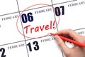 Hand drawing a red circle and writing the text TRAVEL on the calendar date 6 February. Travel planning.