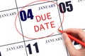 Hand writing text DUE DATE on calendar date January 4 and circling it. Payment due date Royalty Free Stock Photo