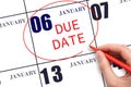 Hand writing text DUE DATE on calendar date January 6 and circling it. Payment due date Royalty Free Stock Photo