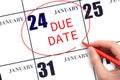 Hand writing text DUE DATE on calendar date January 24 and circling it. Payment due date Royalty Free Stock Photo