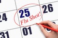 25th day of the month. Hand writing text FLU SHOT and circling the calendar date.