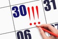 30th day of the month. Hand writing three exclamation marks on calendar date