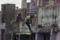 Two construction workers doing repair work of outer wall while hanging by rope. Selective focus Royalty Free Stock Photo