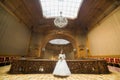 Th horiontal photo of the beautiful bride with the wedding bouquet spending time in the antient baroque palace.