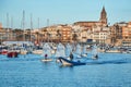 30th International Vila de PalamÃÂ³s Optimist Trophy, 14th Nations Cup. Sailboats sailing to the harbor small town Palamos in