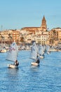 30th International Vila de PalamÃÂ³s Optimist Trophy, 14th Nations Cup. Sailboats sailing to the harbor small town Palamos in