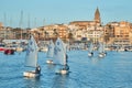 30th International Vila de PalamÃÂ³s Optimist Trophy, 14th Nations Cup. Sailboats sailing to the harbor small town Palamos in