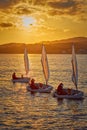 30th International Vila de PalamÃÂ³s Optimist Trophy, 14th Nations Cup. Sailboats sailing to the harbor small town Palamos in