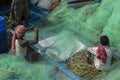 Some fishermen repairing their fishing net before going to sea for fishing
